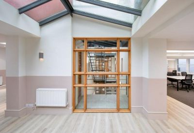Modern hallway with a white radiator and a view into a glass-walled office.