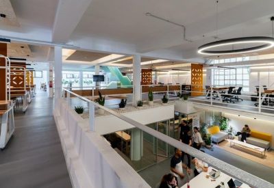 Bright multi-level coworking area with circular pendant light and breakout spaces.