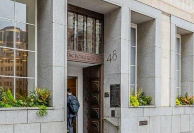 Building entrance with heavy wooden doors and modern grey stone surrounds.