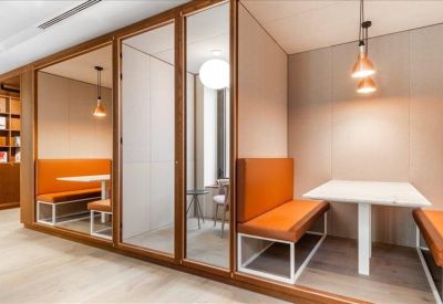 Private meeting pods with orange bench seating and glass doors.