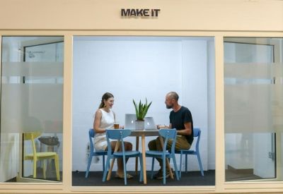 Glazed meeting pod labeled Make It with two people working at a table.