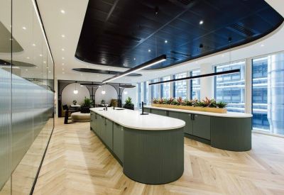 Communal kitchen island with green cabinetry and a white countertop.