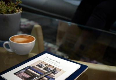 Coffee and business cards on a glass table in a comfortable lounge area.