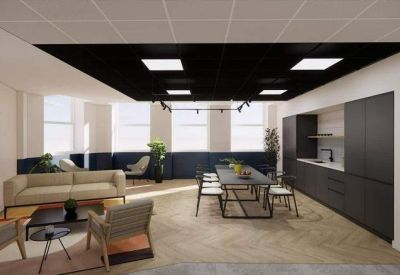 Communal kitchen and lounge area with dark cabinetry and a long dining table.