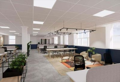 Spacious open-plan workspace with multiple desks and indoor greenery.