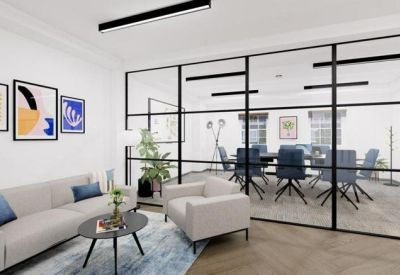 Modern lounge area separated from a glass-walled meeting room by a black frame partition.