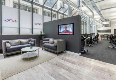 Sleek reception area with modern couches and a wall-mounted TV.