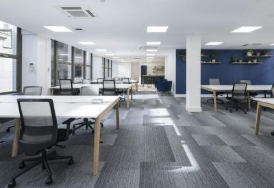 Open-plan workspace with multiple desks and natural light.