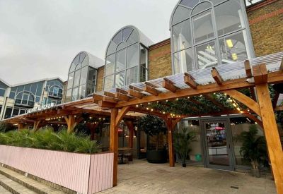 Exterior view of the arched glass windows and wooden pergola entrance at 52, Upper Street, London.