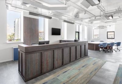 Professional reception area with a dark wood desk and polished grey floors.