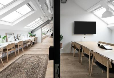 Meeting room with a wall-mounted screen and view through a glass partition.