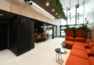 Stylishly furnished lounge area with vibrant orange sectional seating and a coffee bar.