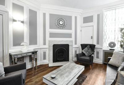 Elegant meeting room with ornate wall moulding, a fireplace, and comfortable seating.