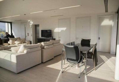 Bright dining and meeting area with a dark table, sleek chairs, and minimalist white walls.