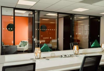 Executive office with glass partitions and orange feature walls.