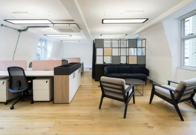 Bright lounge and break area featuring a velvet sofa and stylish armchairs.