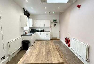 Communal kitchen area with wooden table and benches