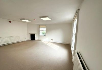 Large empty room with windows and a fireplace