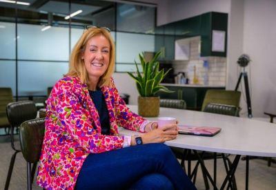 Professional at a white conference table in a modern kitchen breakout area.