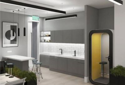 Modern communal kitchen and breakout area with a yellow phone booth and stylish lighting.