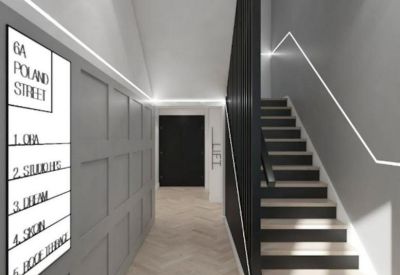 Building hallway featuring a directory board, grey wall paneling, and a staircase.