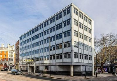 Exterior view of the modernist white office building with grid windows.