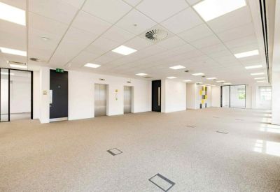 Wide office interior showing grey elevators and recessed ceiling lighting.