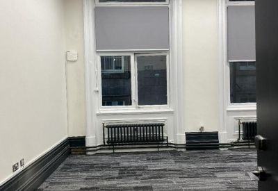 Bright office space with modern linear lighting and traditional arched windows.