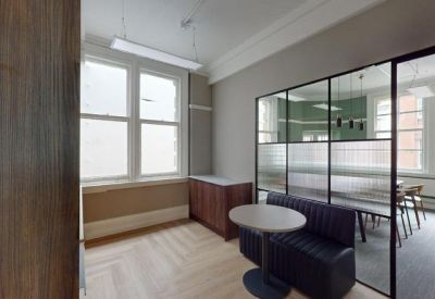 Private office nook separated by a black-framed glass partition.
