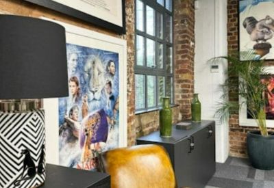 Breakout area featuring a vintage leather armchair, patterned lamps, and exposed brick walls.