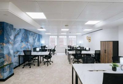 Bright open-plan workspace featuring a blue marble-effect accent wall and white desks.