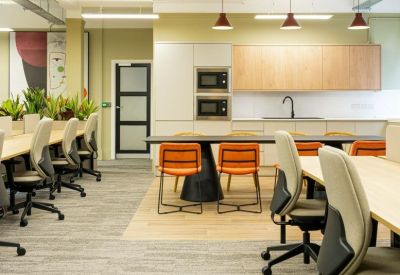 Bright breakout space with a modern kitchen, breakfast bar, and workspace.