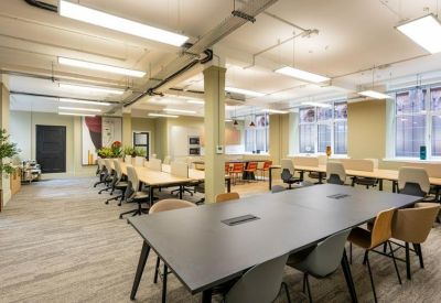 Private meeting room with teal walls, a light wood table, and abstract artwork.
