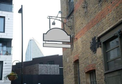 Close-up of a traditional hanging sign bracket on a brick building exterior.
