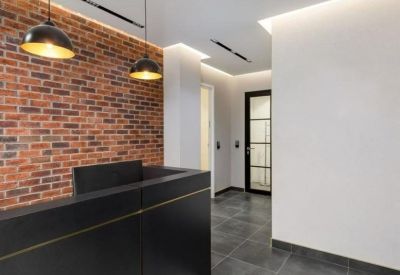 Modern reception area featuring a black desk, exposed brick wall, and stylish pendant lighting.