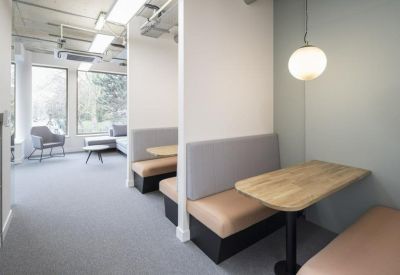 Private meeting booths with tan leather seating and wooden tables.