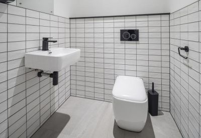 Modern bathroom with white vertical tiles and black hardware.