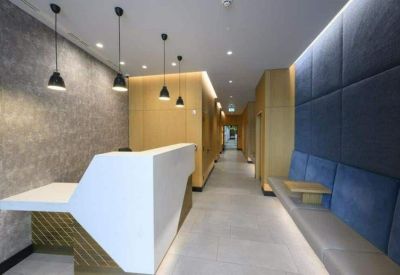 Reception area featuring a white angular desk and a blue quilted feature wall.