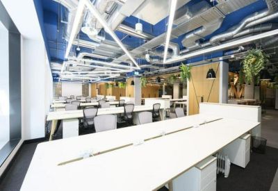 Spacious workstation area with white desks, blue accents, and modern lighting.