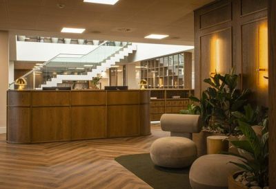 Professional reception desk with wood paneling and views of a central staircase.