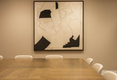 Close-up of a boardroom table with abstract art on the wall.