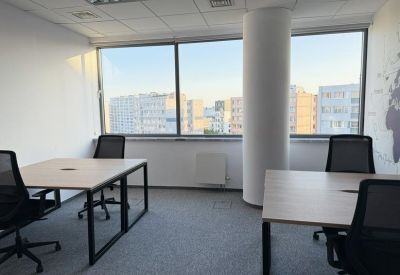Bright internal office suite with two workstations and a large window.