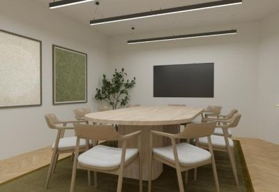 Compact meeting room with oval table and large screen on the wall.