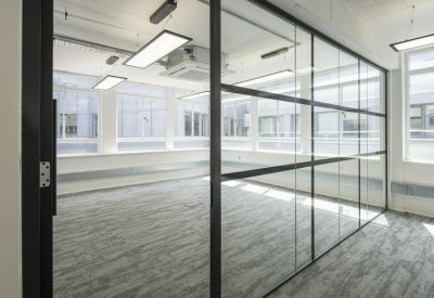 Bright workspace featuring glass partition walls and modern rectangular pendant lighting.