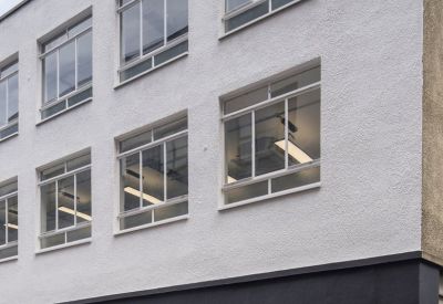 Exterior view of the white facade and dark storefront of 7, Charterhouse Bldgs, London.