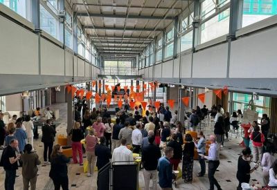 High-ceilinged lobby area filled with people during a social gathering.