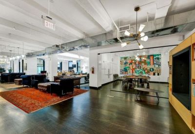 Open-plan lounge area with an orange area rug and eclectic mid-century furniture.