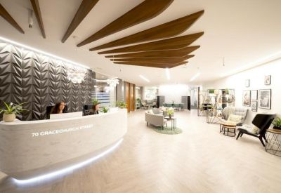 Bright reception area featuring a white curved desk and warm wood ceiling slats.