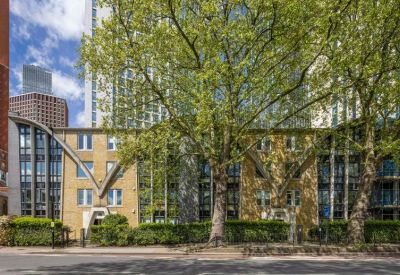 Close-up of the architectural facade at 70 South Lambeth Road framed by lush green trees.