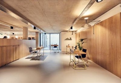Modern coworking lounge with wooden walls and minimalist workstations.